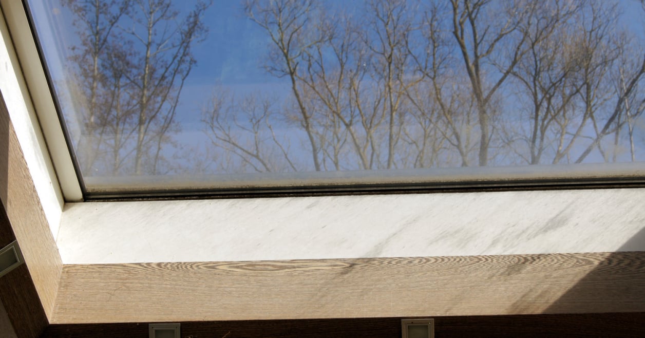 Schmutzablagerung am unteren Fensterrand eines Dachfensters