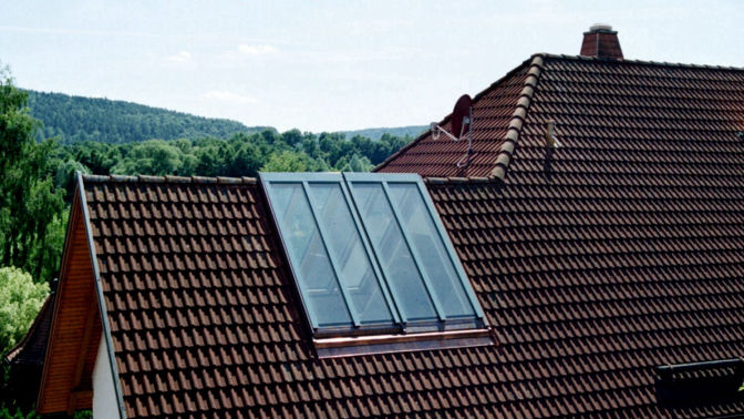 Winkelförmiges Fenster, das über beide Seiten des Dachfirstes geht